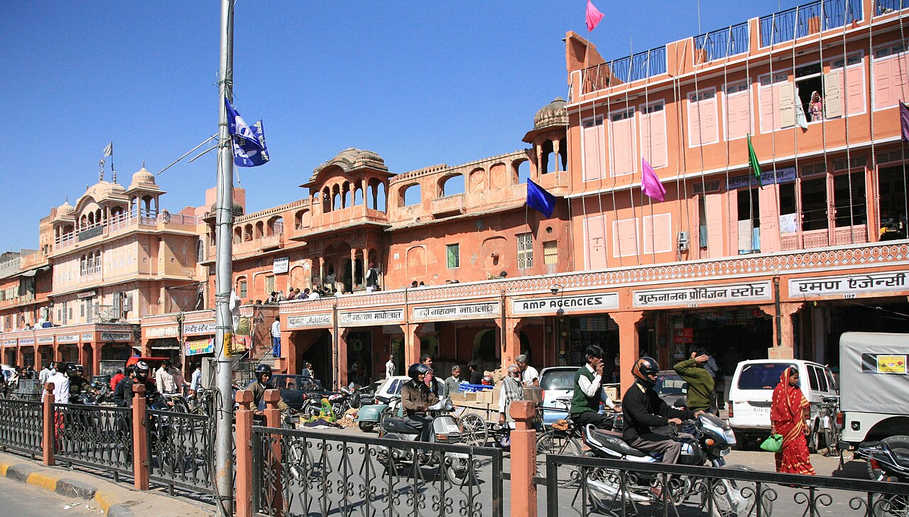 Traffic and shops along the pink facades of Tripolia Bazaar in Jaipur.